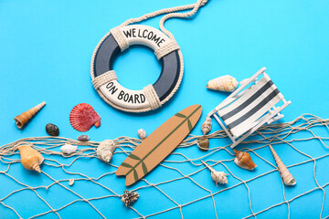 Lifebuoy ring, deckchair, surfboards and seashells on blue background. Summer concept
