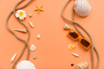 Beautiful seashells, sunglasses and starfish on orange background. Summer concept