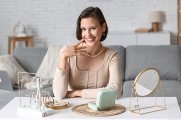 Beautiful young happy woman with stand and storage box of different stylish jewelry at home