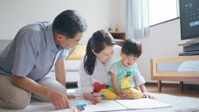 2歳の孫とお絵描きをするシニア夫婦