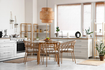 Dining table, chairs and lamp in stylish kitchen