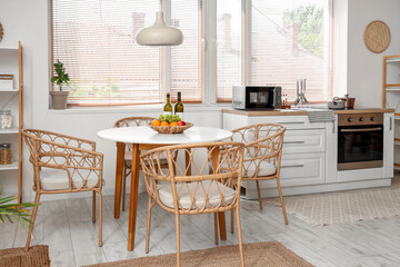 Interior of stylish kitchen with dining table, chairs and lamp