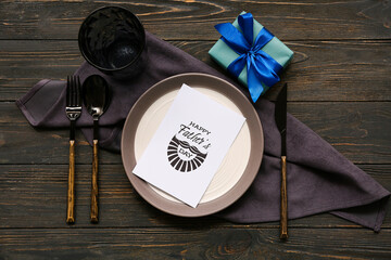 Beautiful table setting with greeting card on black wooden background. Father day celebration...