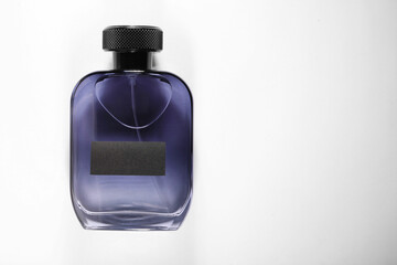 Luxury men`s perfume in bottle on white background, top view. Space for text