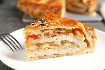 Piece of tasty homemade pie with filling served on grey table, closeup