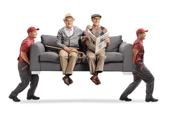 Elderly men sitting on a sofa carried by movers