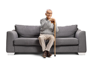 Elderly man sitting on a gray sofa and smiling