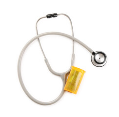 Stethoscope and container with pills isolated on white, top view. Medical tool