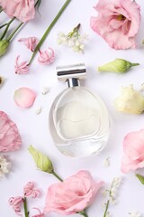 Luxury perfume and floral decor on white background, flat lay