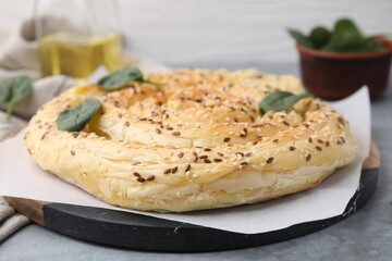 Delicious puff pastry with spinach on grey table, closeup