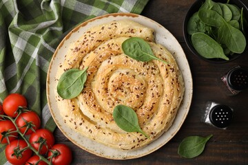 Delicious puff pastry with spinach on wooden table, flat lay