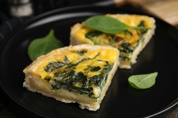 Pieces of delicious pie with spinach on table, closeup