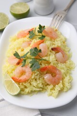Delicious risotto with shrimps, lime and parsley on white table, closeup