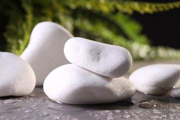 White spa stones with water drops on grey background, closeup