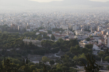Obraz premium The Temple of Hephaestus with the city of Athens, Greece, behind it.