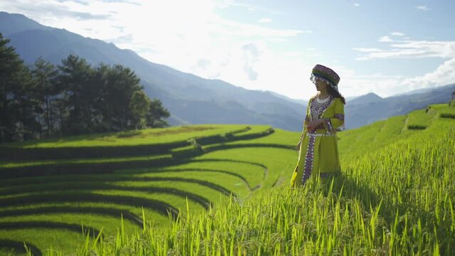 A farmer woman with fresh paddy rice terraces, green agricultural fields in countryside or rural area of Mu Cang Chai, mountain hills valley in Asia, Vietnam. Nature landscape. People lifestyle.