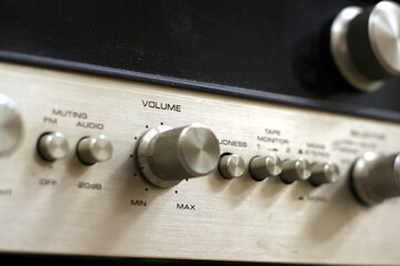 A close-up of a vintage style amplifier, with the focus on the volume switch.