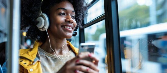 african american girl on the city bus with mobile phone and headphones listening to music