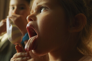 A girl playfully pokes her tongue out while eating ice cream
