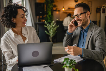 Two colleagues man and woman work together at cafe or restaurant