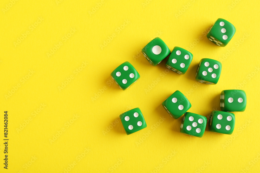 Sticker Many green game dices on yellow background, flat lay. Space for text