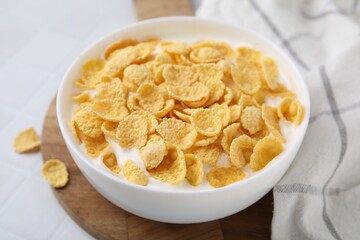 Breakfast cereal. Tasty corn flakes with milk in bowl on white table, closeup