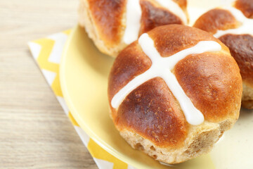 Tasty hot cross buns on wooden table, closeup