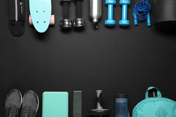 Frame made of different sports equipment on black background, flat lay. Space for text