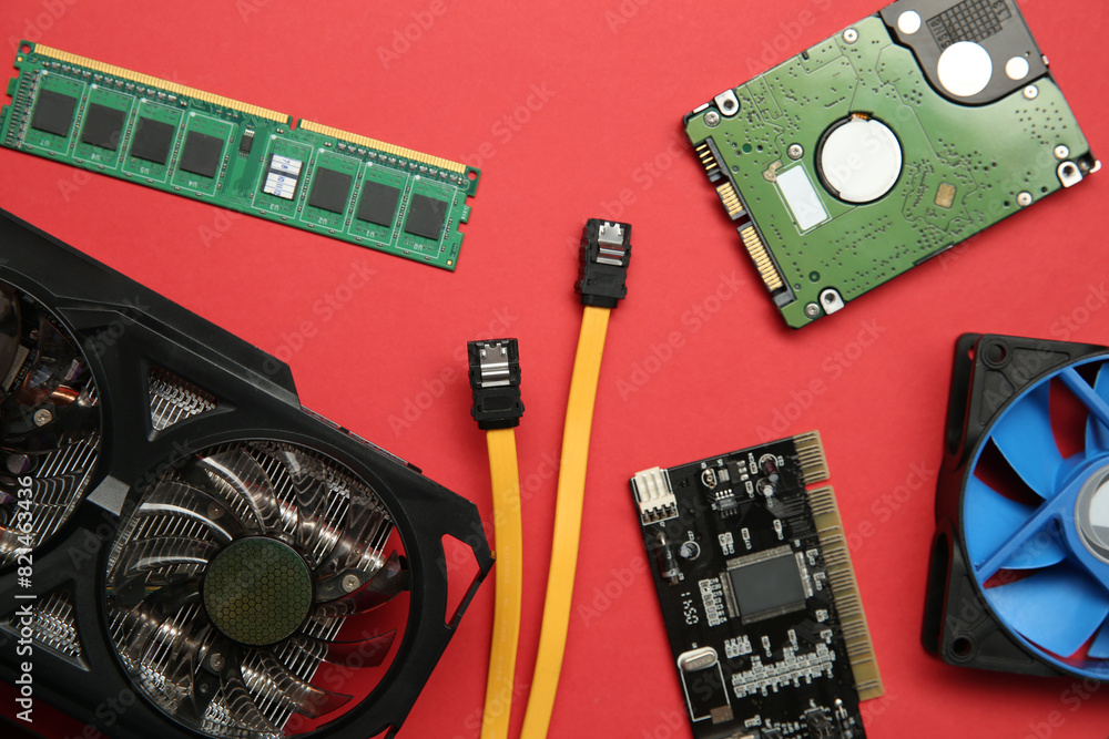 Poster graphics card and other computer hardware on red background, flat lay