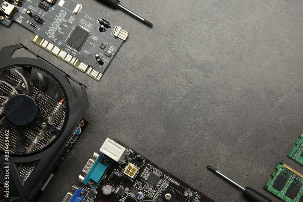 Fototapete graphics card and other computer hardware on grey textured table, flat lay. space for text