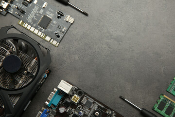 Graphics card and other computer hardware on grey textured table, flat lay. Space for text