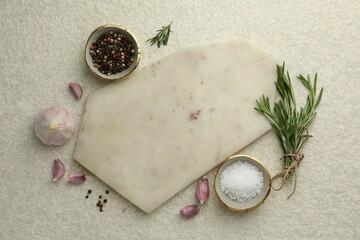 Cutting board, salt, pepper, rosemary and garlic on white textured table, flat lay. Space for text