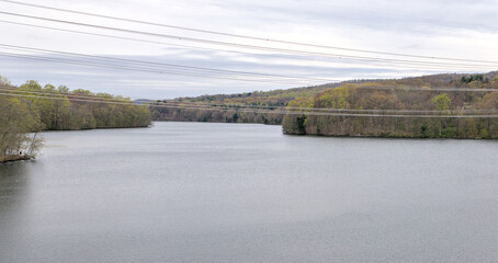 view of new croton aqueduct with power lines from railroad trestle (walking pedestrian cycling path on empire state trail putnam railroad) trees water pond lake scenic hiking travel © Yuriy T