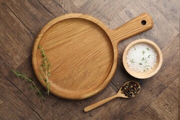 Cutting board and different spices on wooden table, flat lay