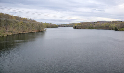 view of new croton aqueduct with power lines from railroad trestle (walking pedestrian cycling path on empire state trail putnam railroad) trees water pond lake scenic hiking travel