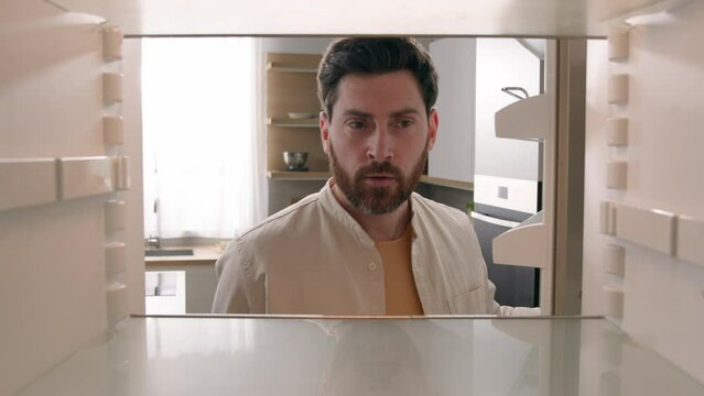 POV point of view from inside refrigerator Caucasian hungry man adult male guy open empty fridge no food without products buying with smartphone order delivery mobile phone app supermarket online