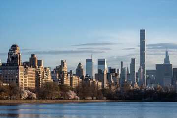 View of Manhattan’s buildings from Central Park’s pond at evening time. Early spring in New York before flowering trees