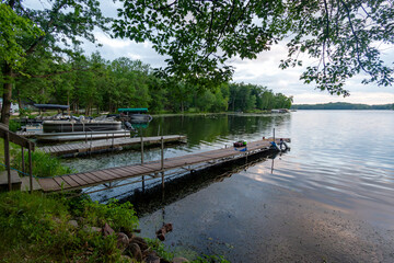 Looking out onto a Wisconsin northwoods lake as the last rays of sunlight begin to fade.  Many pontoon boats have returned from fishing for the evening.