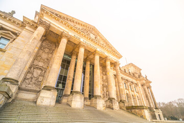 The Reichstag Building bathes in the warm glow of the setting sun, highlighting its neoclassical...