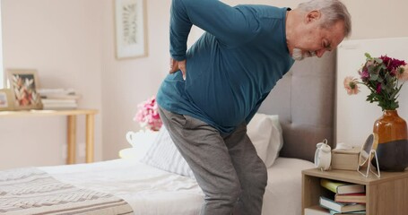 Senior man, bed and back injury with pain from slip disk, nerve or inflammation at home. Elderly male person with sore spine or ache in bedroom for muscle tension, strain or fibromyalgia at house