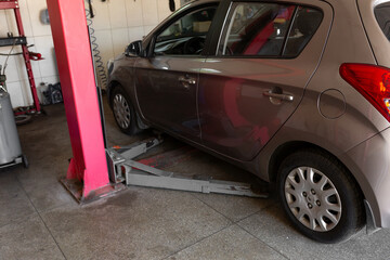 Car lift under a car for under the bottom of a car. The car is top notch. mechanical tools for car repair. car service center