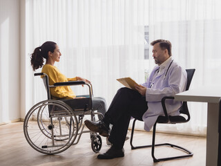Portrait health care latin american woman sick sit wheelchair with man doctor caucasian two people check and treat patients talk help support explain medicine sick person inside hospital clinic room