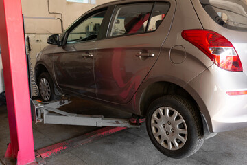 Car lift under a car for under the bottom of a car. The car is top notch. mechanical tools for car repair. car service center
