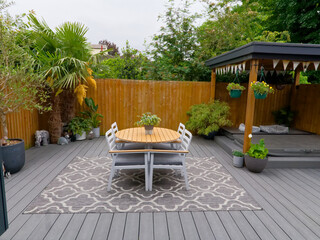 Stylish summer exterior concept with modern house. View of a stylish outdoor wooden floor patio...