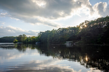 Naklejka premium Looking out onto a Wisconsin northwoods lake as the last rays of sunlight begin to fade. Many boats have returned from fishing for the evening