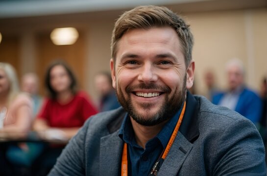 Smiling man sitting in conference room with other attendees - Happy businessman in meeting
