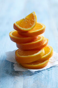 Freshly cut orange slices stacked on a blue background..Freshly cut orange slices stacked on a blue background