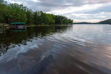 Looking out onto a Wisconsin northwoods lake as the last rays of sunlight begin to fade.  Many...