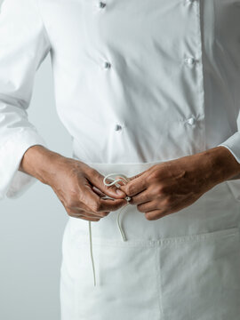 Chef tying apron in chefs whites