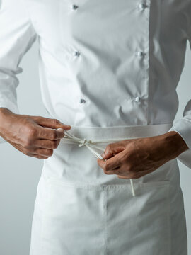 Chef tying apron in chefs whites
